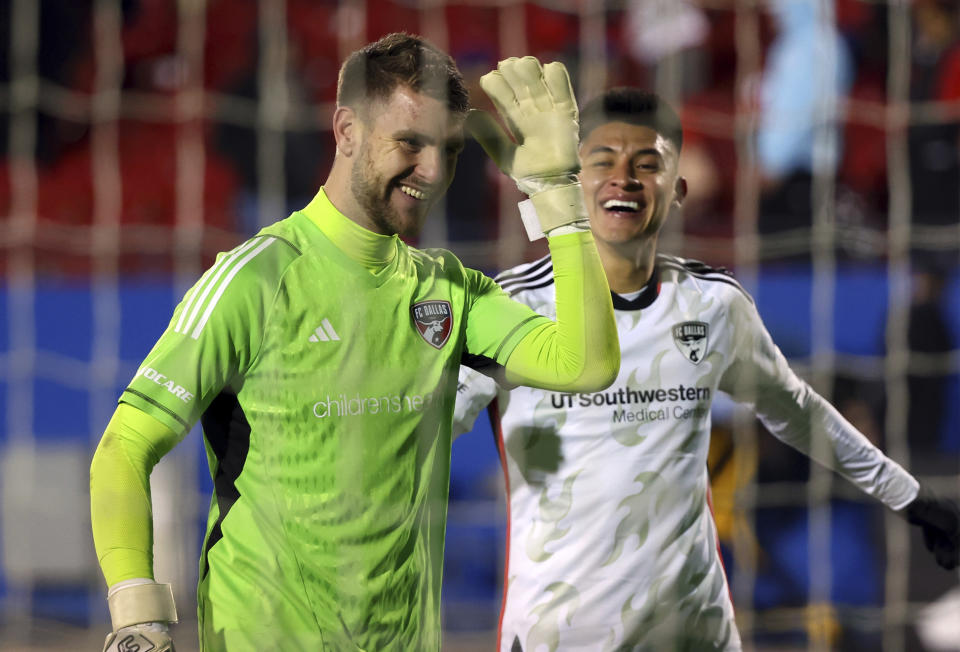 Dallas goalkeeper Maarten Paes (30) and defender Marco Farfan (4) react after the win over Sporting Kansas City in the second half of an MLS soccer match, Saturday, March 18, 2023, in Frisco, Texas. (AP Photo/Richard W. Rodriguez)