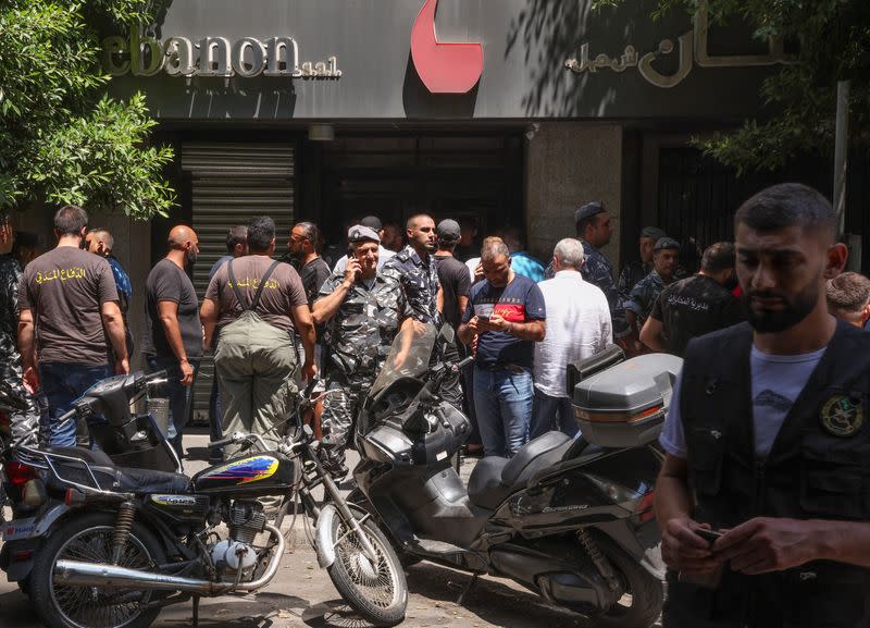 Members of Lebanese police and civil defence secure the area outside Federal bank in Hamra