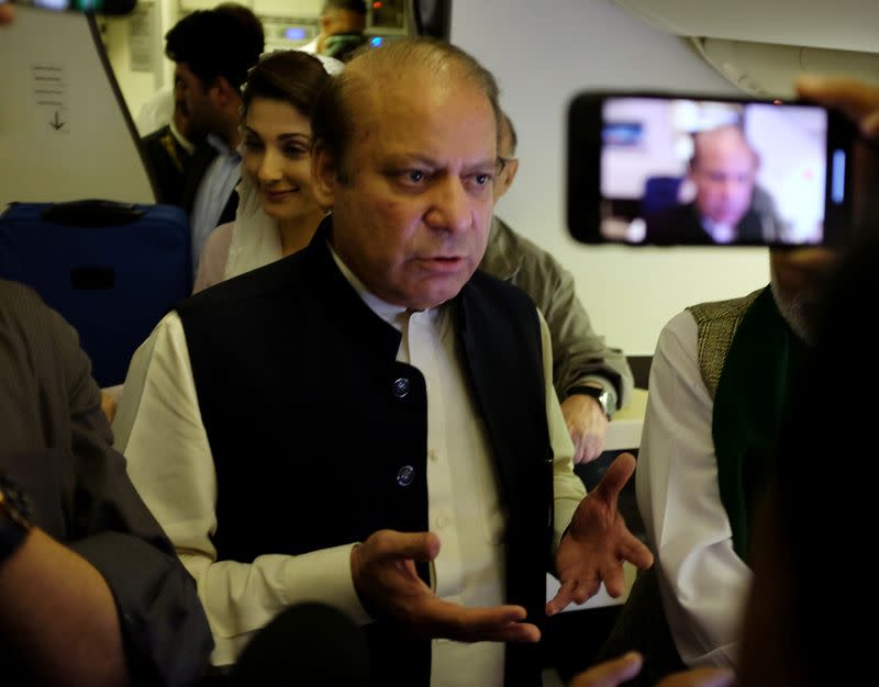 Ousted Pakistani Prime Minister Nawaz Sharif gestures as he boards a Lahore-bound flight due for departure, at Abu Dhabi International Airport