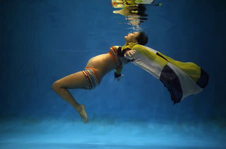 Jiejin Qiu, who is six months pregnant with her first baby, poses underwater during a photo shoot at a local wedding photo studio in Shanghai September 5, 2014. REUTERS/Carlos Barria