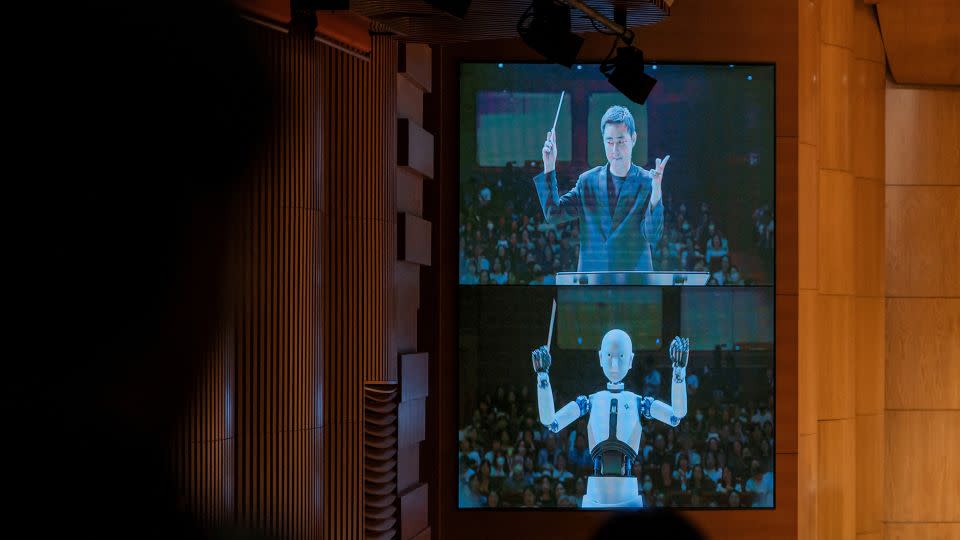 EveR 6 is seen on a screen alongside human conductor Choi Soo-yeoul. - National Theater of Korea/Handout/Reuters