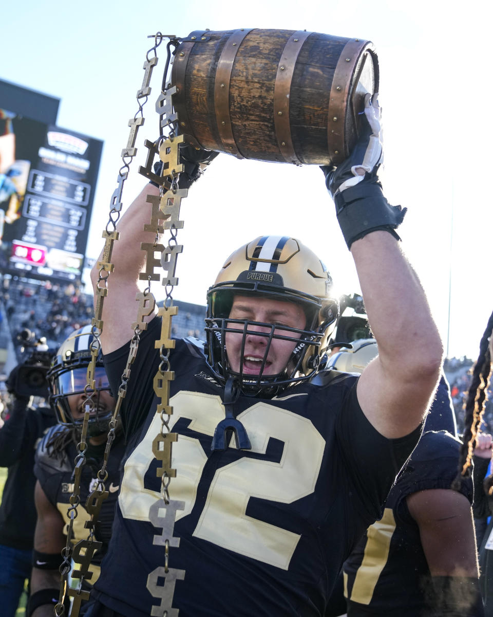 Purdue offensive lineman Ben Kuhns (62) carries the Old Oaken Bucket as he celebrates with teammates after Purdue defeated Indiana in an NCAA college football game in West Lafayette, Ind., Saturday, Nov. 25, 2023. Purdue defeated Indiana 35-31. (AP Photo/Michael Conroy)