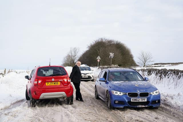 Vehicles attempt to travel along the snow-covered A515 near Biggin