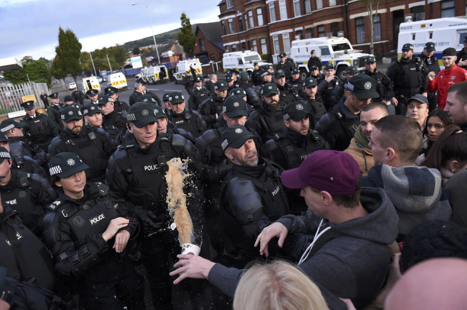 <p>A hot drink is thrown at police during a clash in the nationalist Ardoyne area as residents protest against a decision to allow the return of the loyalist Orange order parade through Ardoyne, in Belfast, Northern Ireland, Oct. 1, 2016. (Photo: Clodagh Kilcoyne/Reuters)</p>