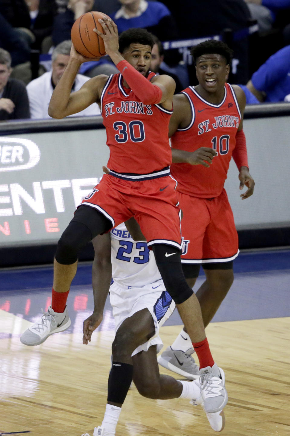 St. John's LJ Figueroa (30) passes the ball in front of Creighton's Damien Jefferson (23) and St. John's Marcellus Earlington (10) during the first half of an NCAA college basketball game in Omaha, Neb., Saturday, Feb. 8, 2020. (AP Photo/Nati Harnik)