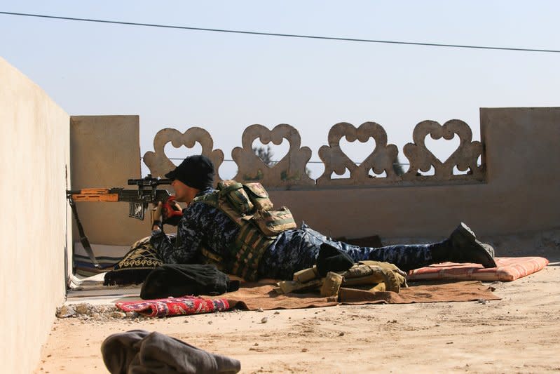 A sniper from Iraq's Federal Police force takes aim at Islamic State positions from the roof of a house on the frontline in Albu Saif, south of Mosul. REUTERS/Alaa Al-Marjani