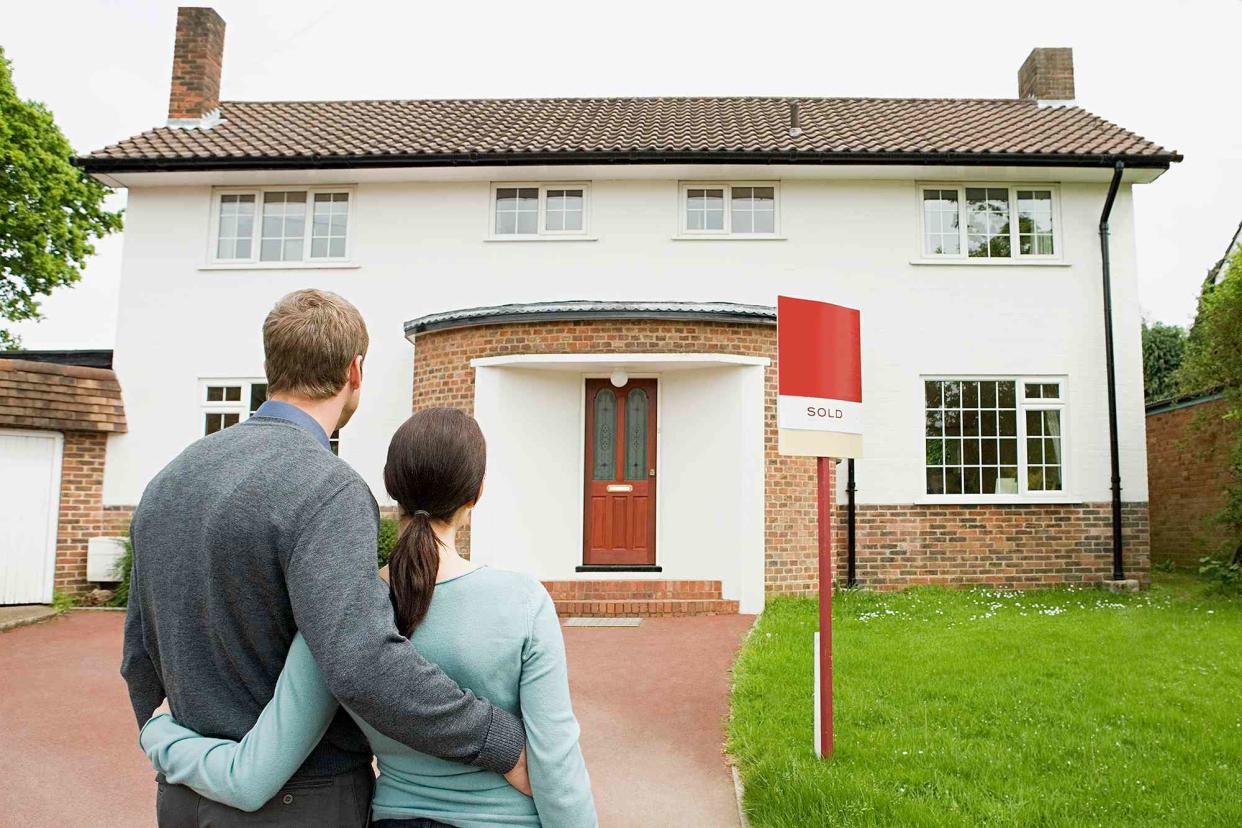 <p>Getty</p> man and woman looking at home for sale