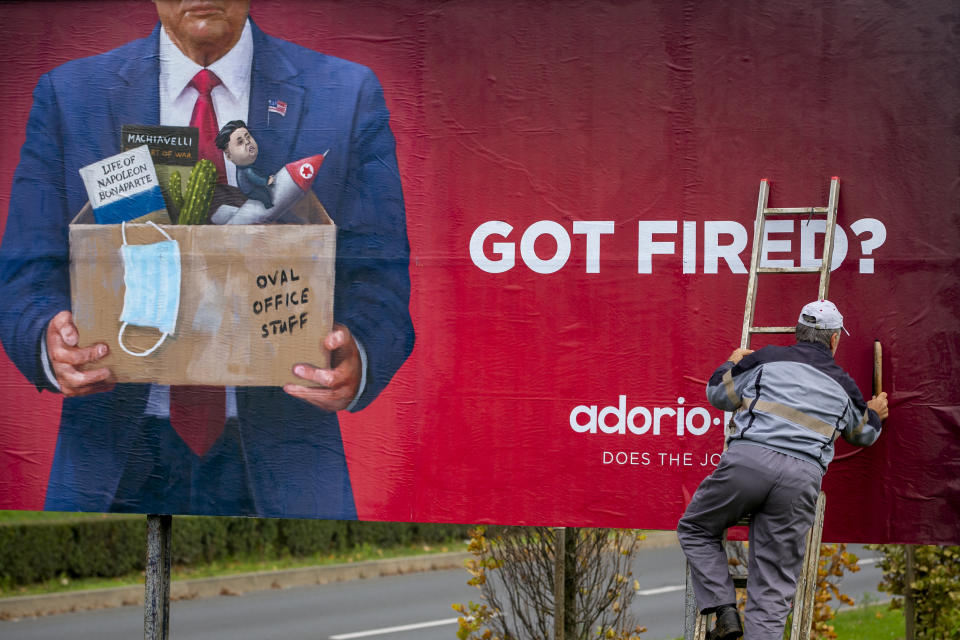 A worker puts up an advertising billboard for a recruiting company, featuring what resembles US President Donald Trump, in Zagreb, Croatia, Saturday, Nov. 7, 2020. (AP Photo/Darko Bandic)