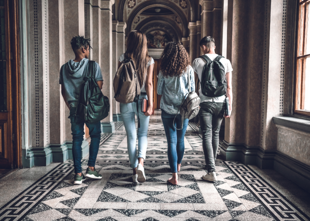 College students walking through an ornate hallway.