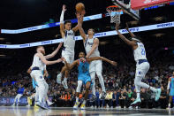 Phoenix Suns forward Mikal Bridges (25) tries to shoot as Dallas Mavericks guard Josh Green (8) and Dallas Mavericks center Dwight Powell defend during the second half of an NBA basketball game, Thursday, Jan. 26, 2023, in Phoenix. (AP Photo/Matt York)