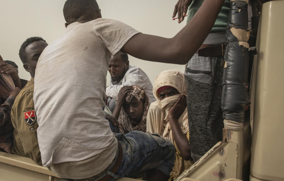 In this July 24, 2019 photo, Ethiopian migrants sit in the back of a pickup truck to be taken to desert compounds known in Arabic as "hosh," in Ras al-Ara, Lahj, Yemen. The AP spoke to more than two dozen Ethiopians who survived torture at Ras al-Ara. Nearly all of them reported witnessing deaths, and one man died of starvation hours after the AP saw him. (AP Photo/Nariman El-Mofty)