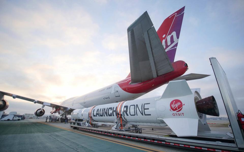 The completed Virgin Orbit LauncherOne rocket hanging from the wing of Cosmic Girl, a special Boeing 747 aircraft that is used as the rocket's "flying launch pad". - Greg Robinson/Virgin Orbit via AP