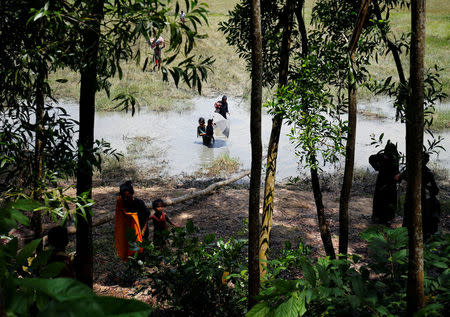 Rohingya people make their way through water as they try to come to Bangladesh side from No Man’s Land after a gunshot was heard on the Myanmar side, in Cox’s Bazar, Bangladesh August 28, 2017. REUTERS/Mohammad Ponir Hossain