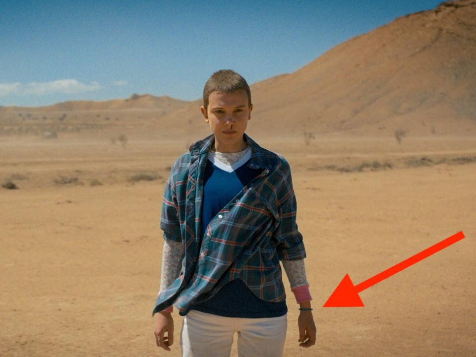 A girl standing in a desert landscape.