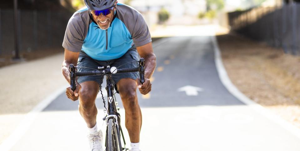 senior black man racing on a road bike