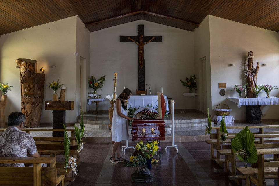 French-born artist Delphine Poulain attends the funeral service of a friend at the Holy Cross Catholic church, in Hanga Roa, Rapa Nui, or Easter Island, Chile, Saturday, Nov. 26, 2022. Rapa Nui – the remote Chilean territory in the mid-Pacific – is home to a Catholic church featuring artwork that reflects that islanders’ ancestral culture as well as Christian beliefs. (AP Photo/Esteban Felix)