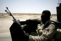 An Iraqi government forces member sits in the back of a vehicle in the Jurf al-Sakher area, some 50 kilometres south of Baghdad, to patrol the area from further Islamic State group advancement, on May 24, 2015