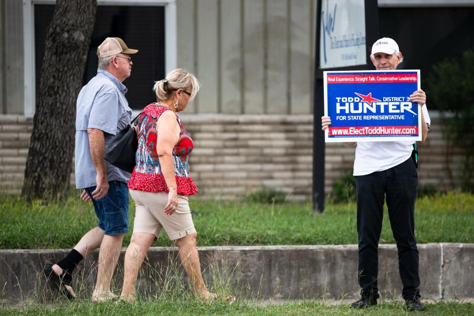 George Hutchinson, a volunteer for the campaign of state Rep. Todd Hunter, R-Corpus Christi, holds a campaign sign for Hunter on the first day of early voting at the Deaf & Hard of Hearing Center in Corpus Christi on Monday, Oct. 24, 2022.