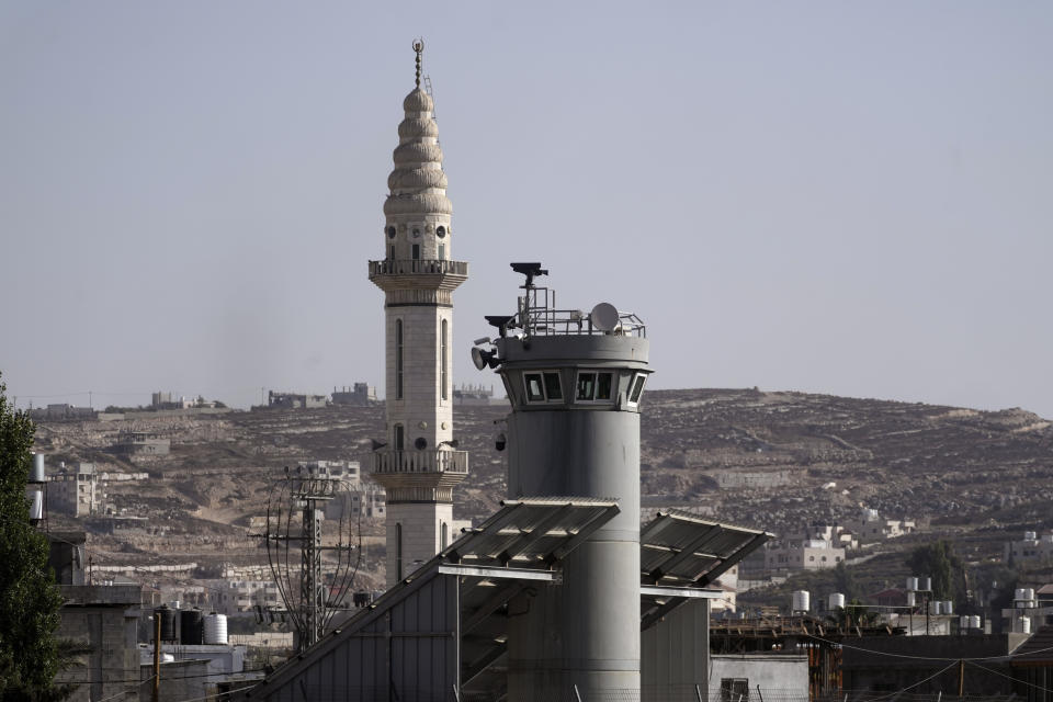 An Israeli military guard tower with two robotic guns and surveillance cameras at the Aroub refugee camp in the West Bank, Thursday, Oct. 6, 2022. Israel has installed robotic weapons that can fire tear gas, stun grenades and sponge-tipped bullets at Palestinian protesters. The robots, perched over a crowded Palestinian refugee camp and in a flash point West Bank city, use artificial intelligence to track targets. (AP Photo/Mahmoud Illean)