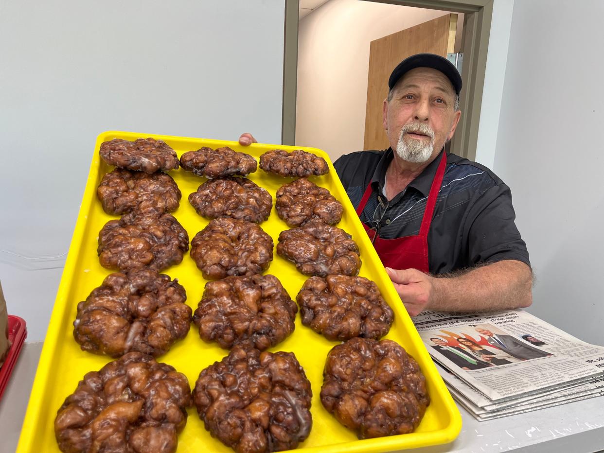 John Khoury holds a tray of fresh apple fritters at Mt. Juliet Donut Shop.