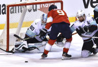 Florida Panthers center Sam Bennett (9) tries to get a shot away as Seattle Kraken goaltender Chris Driedger (60) and defenseman Adam Larsson (6) close in on the puck during the first period of an NHL hockey game Saturday, Nov. 27, 2021, in Sunrise, Fla. (AP Photo/Jim Rassol)