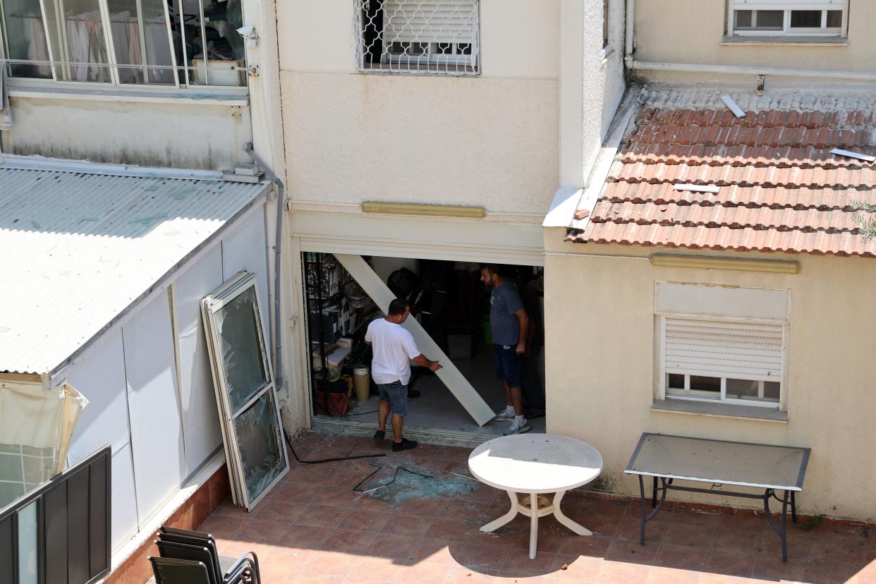 Residents check the damage caused by a rocket fired from Lebanon in the Israeli coastal town of Acre (AFP via Getty Images)