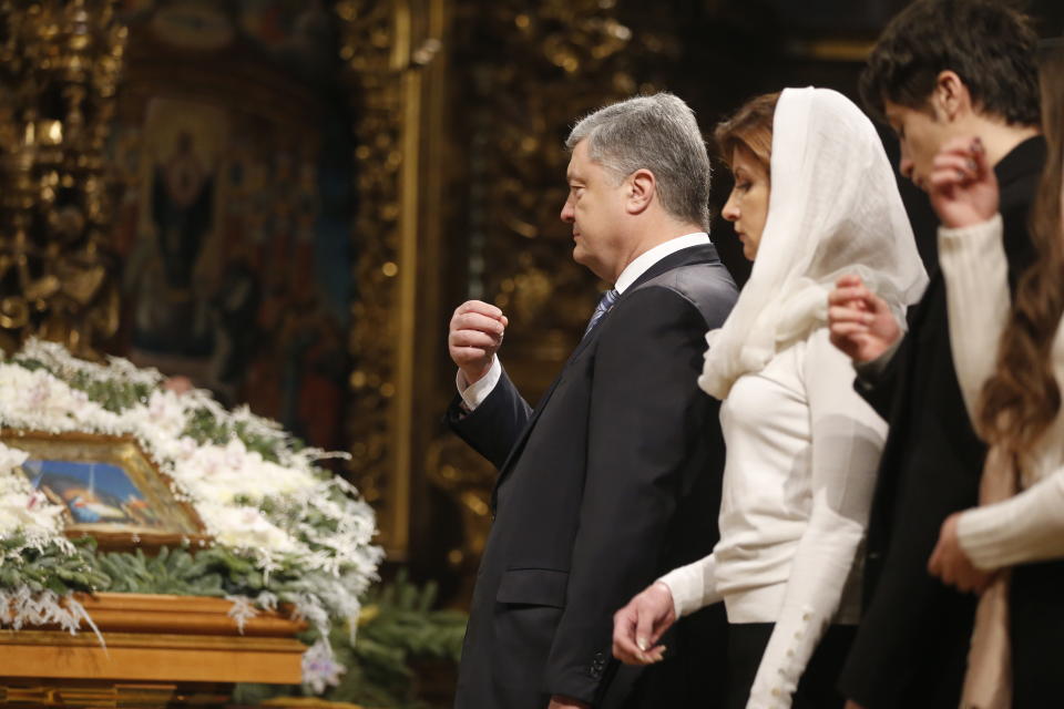 Ukrainian President Petro Poroshenko, third right, his wife Maryna, second right, and his son cross themselves during the service marking Orthodox Christmas and celebrating independence of Ukrainian Orthodox Church in the St. Sophia Cathedral in Kiev, Ukraine, Monday, Jan. 7, 2019. (AP Photo/Efrem Lukatsky)