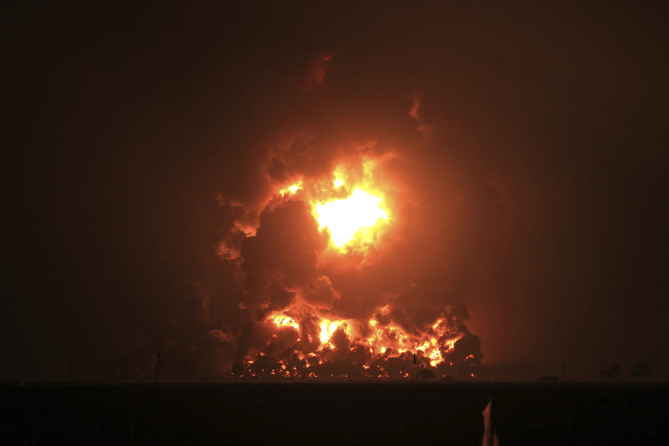 Night sky glows from a fire that razes through Pertamina Balongan Refinery in Indramayu, West Java, Indonesia, early Monday, March 29, 2021. Hundreds of people were evacuated from a nearby village after the massive fire broke out at the refinery. (AP Photo)