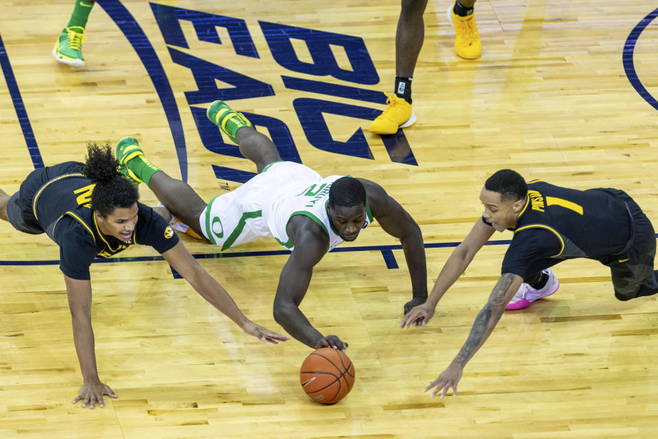 Missouri guard Dru Smith (12), Oregon forward Eugene Omoruyi (2), and Missouri guard Xavier Pinson (1) go after a loose ball during the first half of an NCAA college basketball game, Wednesday, Dec. 2, 2020 in Omaha, Neb. (AP Photo/John Peterson)