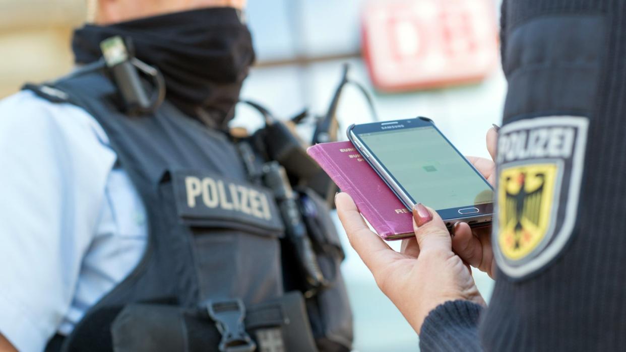 Eine Bundespolizistin scannt mit einem Mobiltelefon einen Reisepass. Foto: Klaus-Dietmar Gabbert