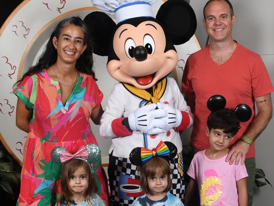 Family posing with Mickey Mouse