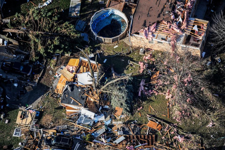 The day after the tornado in 2013, debris is scattered near the home of John and Vicki Ghidina, visible at top right.