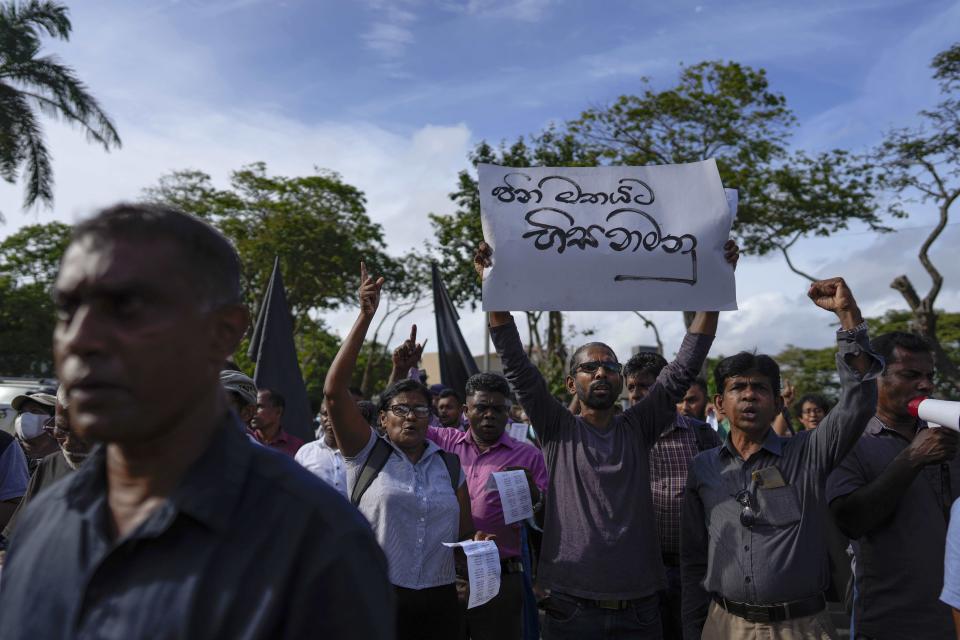 Trade union and civil society activists led by leftists' People Liberation Front shout slogans denouncing president Ranil Wickremesinghe in Colombo, Sri Lanka, Tuesday, Aug. 9, 2022. Placard in Sinhalese reads " Obey the people's mandate". Hundreds of Sri Lankans Tuesday rallied against a government crackdown and the use of emergency laws against those who protested peacefully against the country’s worst economic crisis in recent memory. (AP Photo/Eranga Jayawardena)