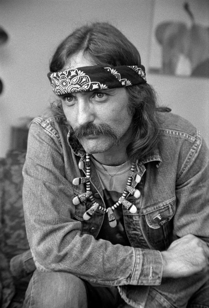 actor Dennis Hopper wearing a handkerchief bandana, blue jeans, jean jacket and a handlebar mustache.