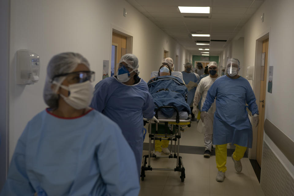 Trabajadores médicos trasladan a la nueva paciente con coronavirus para que sea tratada en el hospital Dr. Ernesto Che Guevara en Marica, Brasil, el jueves 21 de mayo de 2020. (Foto AP/Leo Correa)
