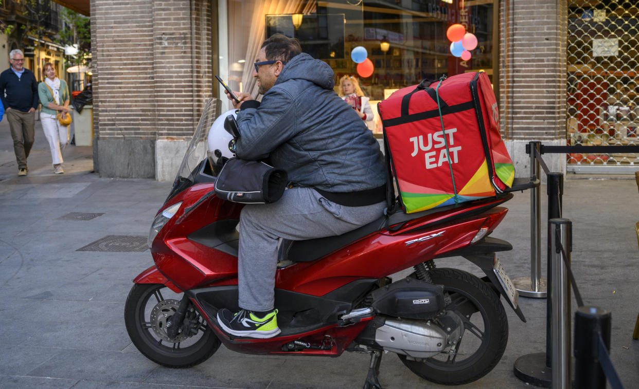 MADRID, SPAIN - MAY 03: A Just Eat courier sits on his scooter while checking on a delivery on May 03, 2019 in Madrid, Spain. Just Eat operates a leading global hybrid marketplace for online food delivery, providing customers with an easy and secure way to order and pay for food from its restaurant partners. (Photo by Horacio Villalobos - Corbis/Corbis via Getty Images)