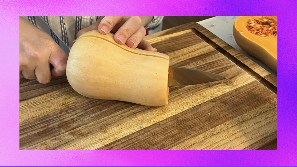 Person cutting butternut squash in half on cutting board.