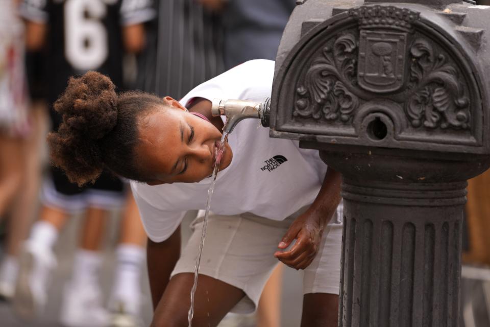 FILE - A girl drinks water from a public fountain tap amid hot weather in Madrid, Spain, July 18, 2023. Climate negotiators gather in Dubai for marathon United Nations talks that include a first-ever assessment of how well the world is doing in its battle against global warming. (AP Photo/Paul White, File)