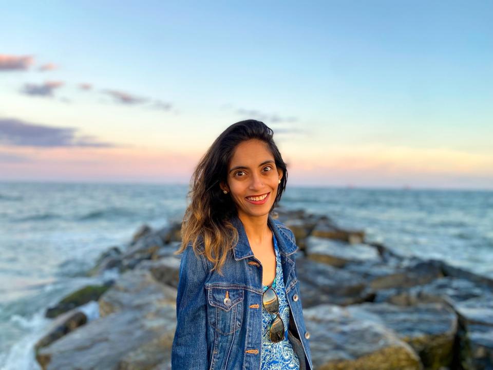 Alka Bhatt on a beach, wearing a denim jacket.