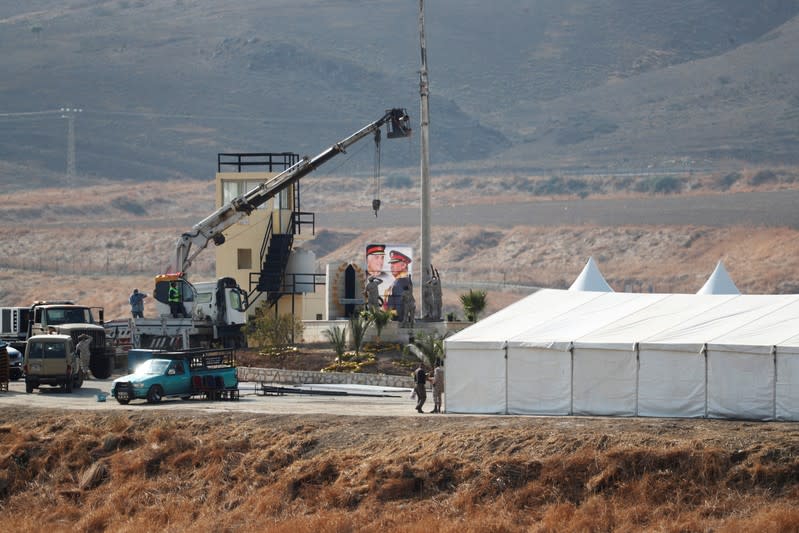 Jordanian soldiers prepare to raise the Jordanian national flag near a tent at the "Island of Peace" in an area known as Naharayim in Hebrew and Baquora in Arabic, on the Jordanian side of the border with Israel, as seen from the Israeli side