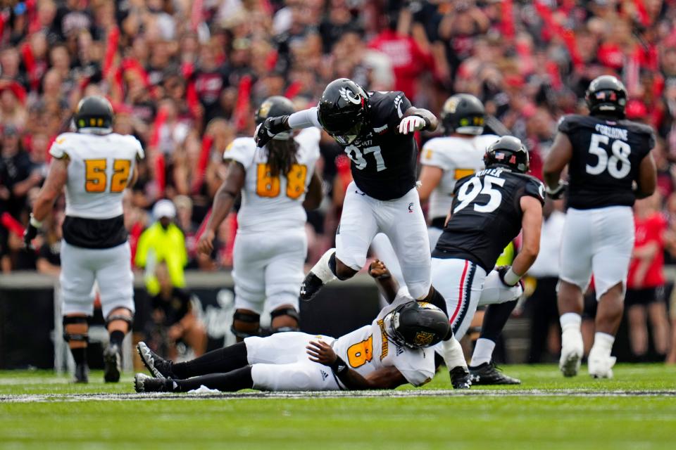 Cincinnati Bearcats defensive lineman Eric Phillips (97) hops over Kennesaw State Owls quarterback Xavier Shepherd (8) after pressuring the throw in the first quarter of the NCAA football game between the Cincinnati Bearcats and the Kennesaw State Owls at Nippert Stadium in Cincinnati on Saturday, Sept. 10, 2022.