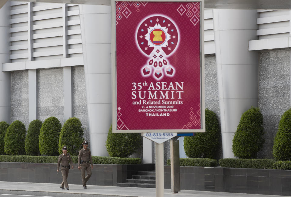 In this Tuesday, Oct. 29, 2019. Thai policemen walk behind banner welcoming Association of Southeast Asian Nations at the venue of The 35th annual Association of Southeast Asian Nations (ASEAN) in Nonthaburi province, Thailand. U.S. national security adviser Robert C. O'Brien and Commerce Secretary Wilbur Ross will represent President Donald Trump at two regional summits in Thailand this weekend, the White House announced, a move that would widely be viewed in the region as a snub.(AP Photo/Sakchai Lalit)