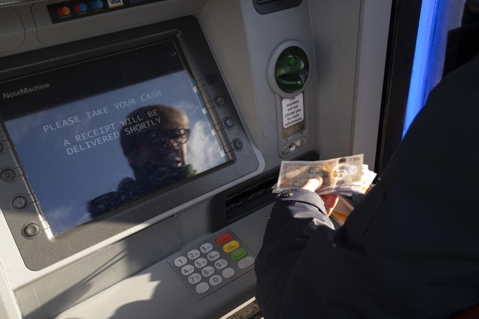 Woman withdraws cash from her bank by using a cashpoint machine on 10th December 2021 in Birmingham, United Kingdom. ATM machines aka automated teller machines are where people are able to access their bank account to withdraw their money. (photo by Mike Kemp/In Pictures via Getty Images)