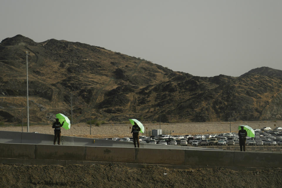 Saudi soldiers hold umbrellas as they stand alert near Arafat camp in Mecca, Saudi Arabia, Wednesday, June 21, 2023. Muslim pilgrims are converging on Saudi Arabia's holy city of Mecca for the largest hajj since the coronavirus pandemic severely curtailed access to one of Islam's five pillars. (AP Photo/Amr Nabil)