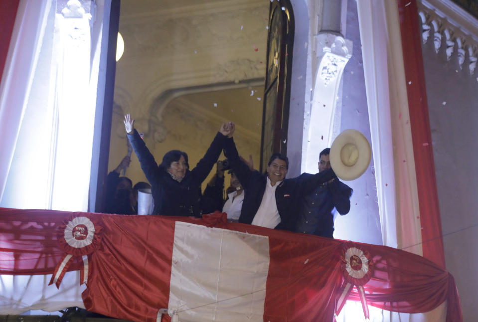 Pedro Castillo, center, celebrates with his running mate Dina Boluarte after being declared president-elect by election authorities at their campaign headquarters in Lima, Peru, Monday, July 19, 2021. Castillo was declared the winner more than a month after elections took place and after opponent Keiko Fujimori claimed that the election was tainted by fraud. (AP Photo/Guadalupe Prado)