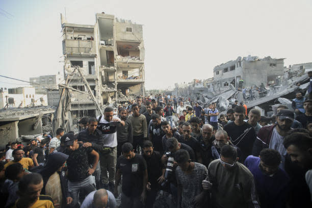 On the 30th day of the Israel-Palestine conflict, dated 5 November 2023, Palestinian civilians and rescue teams comb through the ruins of a collapsed structure in Al-Maghazi, central Gaza Strip (Middle East Images/AFP via Getty)