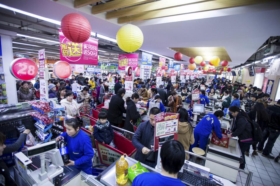 Chinese Customers wait in line to check out by Alipay to enjoy 50% off up to 50 yuan ($7.74) at a supermarket on December 12, 2015. REUTERS/Stringer