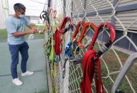 A teacher of the faculty of sport sciences at Universite Cote d'Azur disinfects climbing material in Nice