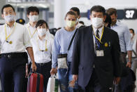 Belarusian Olympic sprinter Krystsina Tsimanouskaya, center, prepares to leave Narita International Airport in Narita, east of Tokyo Wednesday, Aug. 4, 2021. Tsimanouskaya, who plans to seek refuge in Europe, boarded a plane that left the gate for Vienna on Wednesday morning, though it was not immediately clear if that would be her final destination. (Kyodo News via AP)