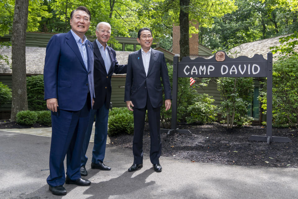 FILE - President Joe Biden greets South Korea's President Yoon Suk Yeol, left, and Japan's Prime Minister Fumio Kishida, right, on Aug. 18, 2023, at Camp David, the presidential retreat, near Thurmont, Md. South Korea’s president says he’ll tell world leaders about the need to faithfully enforce U.N. sanctions on North Korea and block the country’s illicit activities to fund its weapons programs when they converge in Indonesia and India for annual summits this week. (AP Photo/Andrew Harnik, File)